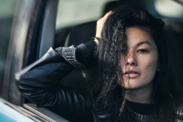 Genç Bir Kadın Açık Pencereli Arabada Otururken Kameraya Poz Veriyor Stok Fotoğraf
