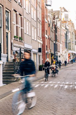 Amsterdam şehir merkezinde yüksek hızla seyahat eden Hollandalı vatandaşlar bisikletle