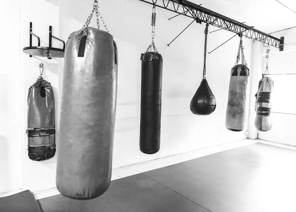 boxing gym with hanging bags, black and white sports photography