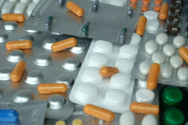 blurred background from various multi-colored assorted pills in blisters. Photo