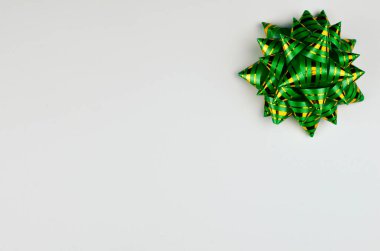 Yeni yıl hediyesi, sağ üst köşedeki beyaz arka planda yeşil fiyonk. Fotoğraf.