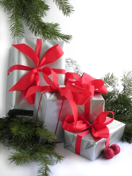 Traditional Christmas gifts with silver paper and red ribbons Royalty Free Stock Images
