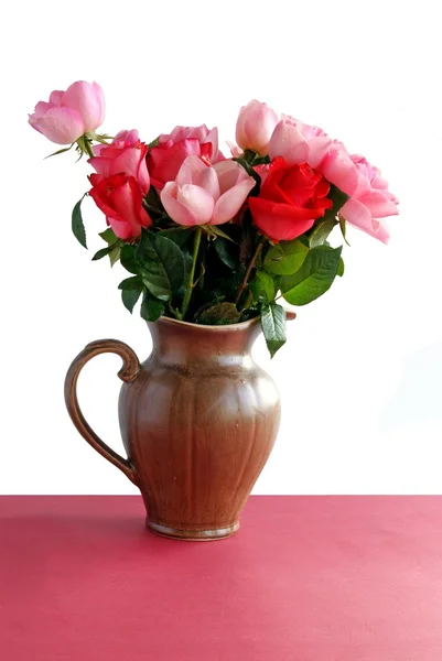 Розовые розы в керамическом кувшине — стоковое фото
