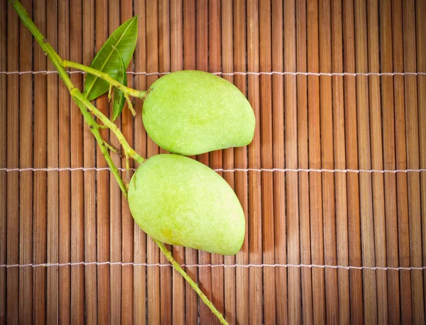 Geen mango fruit macro on bamboo floor — Stock Photo, Image