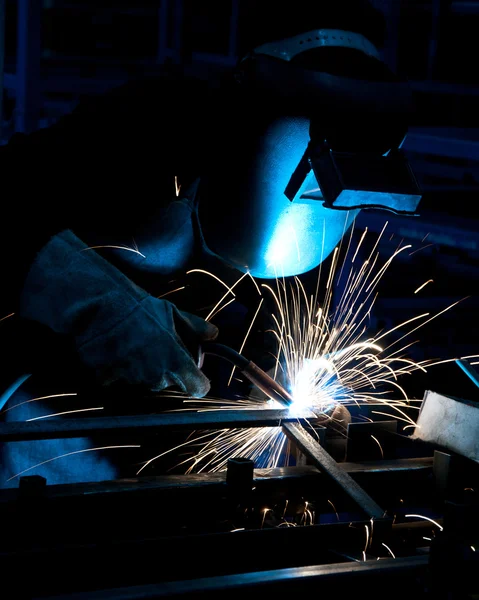 Trabajo humano de soldadura con muchas chispas en una industria metalúrgica —  Fotos de Stock