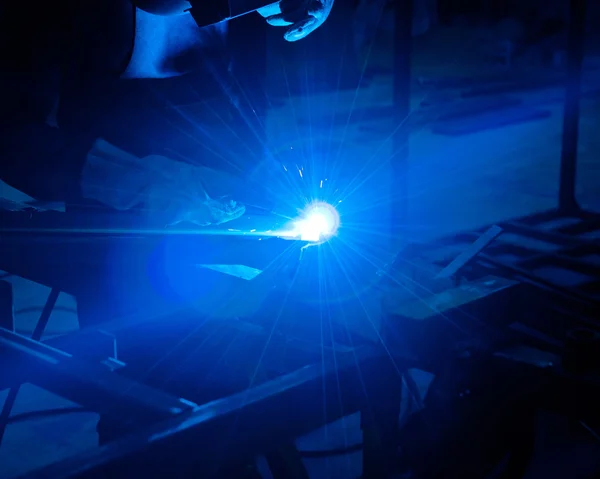 Trabajo humano de soldadura con muchas chispas en una industria metalúrgica —  Fotos de Stock