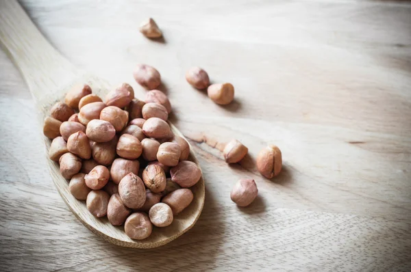 Peanuts closeup on wood ladle — Stock Photo, Image