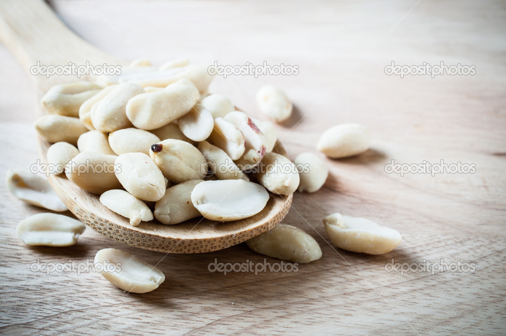 Peanuts on wood ladle closeup