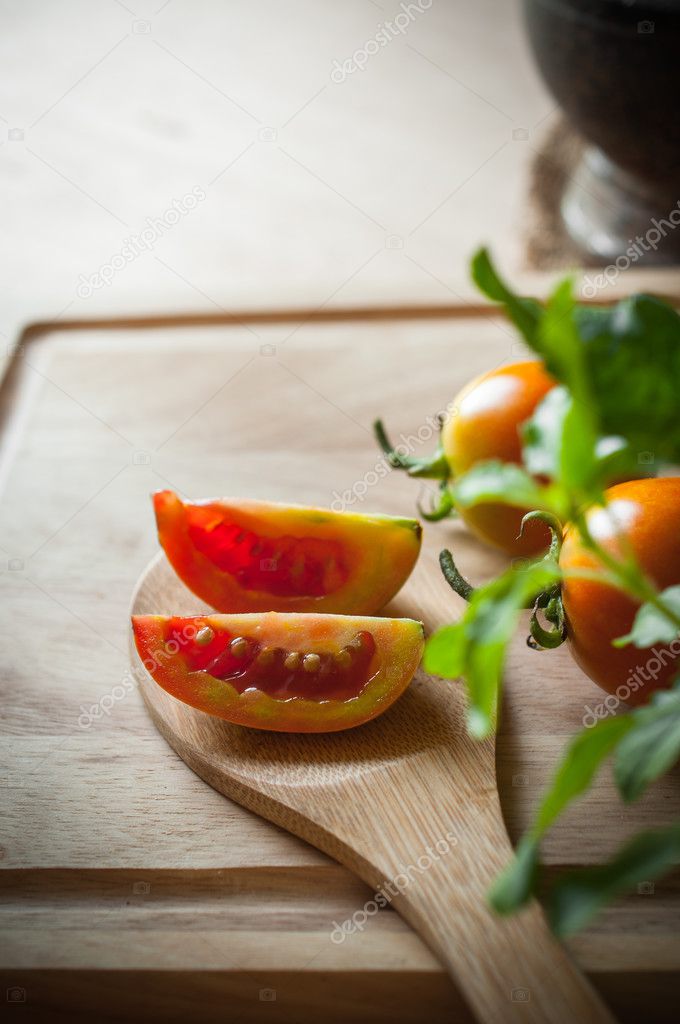 Tomatoes slice on wood ladle closeup