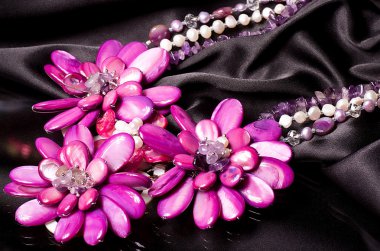 A bead necklace with flowers on black background