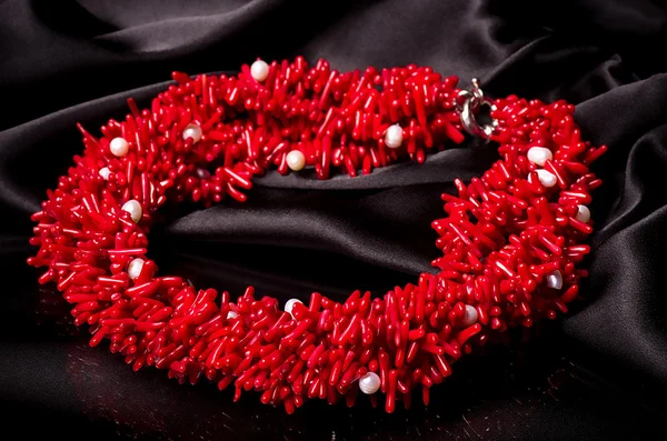 Beautiful red necklace on black material — Stock Photo, Image