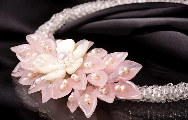Una collana di perle con fiori su sfondo nero — Foto Stock