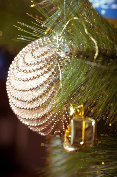 Beautiful golden christmas decorations hanging on christmas tree with shiny glare — Stock Photo, Image