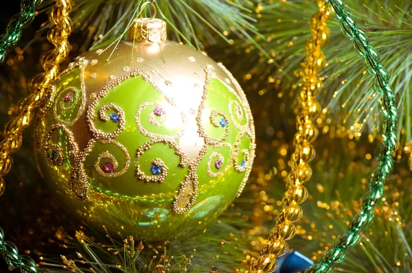 Hermosas decoraciones verdes de Navidad colgando en el árbol de Navidad con resplandor brillante — Foto de Stock