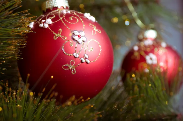 Hermosas decoraciones rojas de Navidad colgadas en el árbol de Navidad con resplandor brillante —  Fotos de Stock
