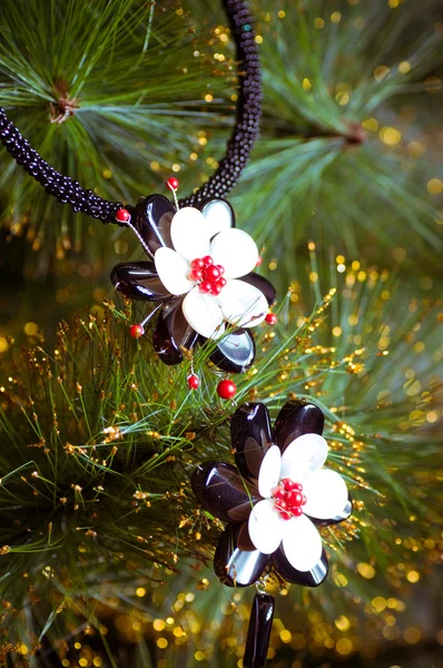 Beautiful necklace on a branch of fir — Stock Photo, Image