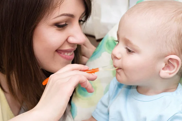 Jovem mãe alimentando bebê menino — Fotografia de Stock