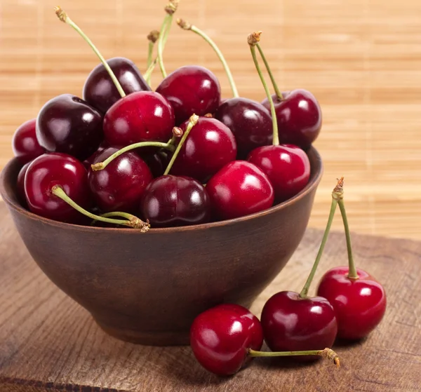 Cherry berries in wooden bowl — Stock Photo, Image