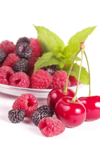 Raspberries, mint and cherries in a bowl isolated on white — Stock Photo, Image
