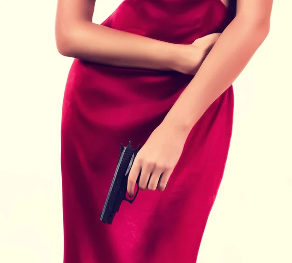 Vacker ung kvinna med revolver i röd klänning — Stockfoto