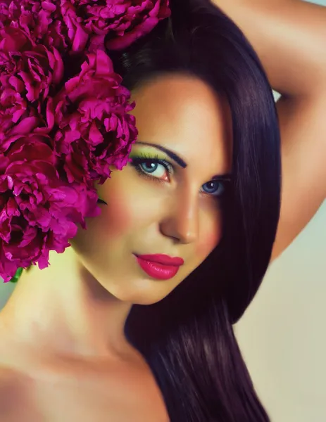Cara de belleza de la joven con flores rojas — Foto de Stock