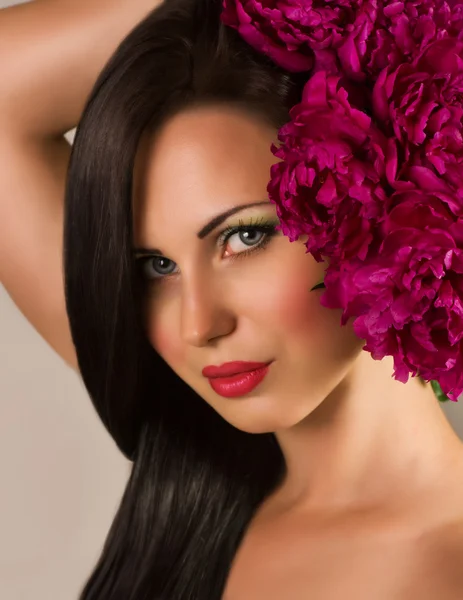Красота лица молодой женщины с красными цветами — стоковое фото