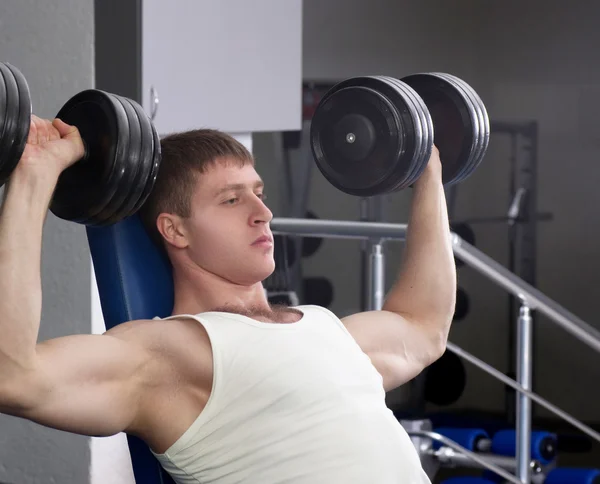 Guapo joven musculoso hombre de deportes en el gimnasio — Foto de Stock