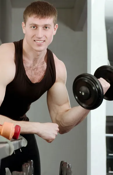 Guapo joven musculoso hombre de deportes en el gimnasio — Foto de Stock