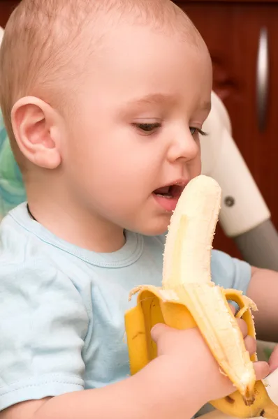 Little baby boy eats banana — Stock Photo, Image