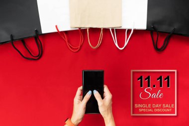 Çin 11.11 tek günlük satış konsepti, kadın akıllı telefonu alışveriş çantasıyla tutuyor..