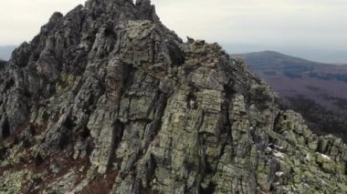 Taganay Ulusal Parkı 'nın havadan görünüşü. Otkliknoy sırtındaki inanılmaz gri kayalar. Kruglitsa Dağı manzarası. Güney Ural. Bulutlu hava, sonbahar, yürüyüş, turizm. İHA video çekimi