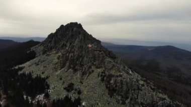 Taganay Ulusal Parkı 'nın havadan görünüşü. Otkliknoy sırtındaki inanılmaz gri kayalar. Kruglitsa Dağı manzarası. Güney Ural. Bulutlu hava, sonbahar, yürüyüş, turizm. İHA video çekimi