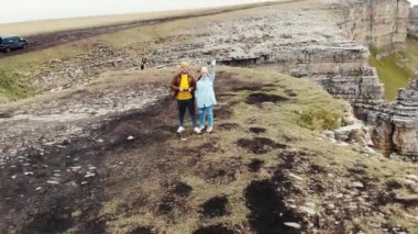 Koyu bulutlardaki taş amfitiyatronun havadan görünüşü, Bermamyt yaylası, Kafkasya. Toprak boyunca uzanan yol boyunca heybetli yamaçların üzerinden uçuyor. Sis dik yamaçtan yukarı çıkıyor. Elbrus bölgesi