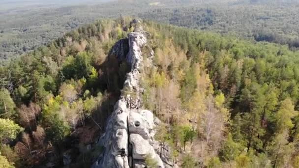 Flygfoto över klippmassivet, Arakul Shikhany, Ural. Bergshöjden ligger bland tät grön skog nära sjöar. Klart väder. Vandring, turism, vild natur — Stockvideo