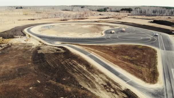 Flygfoto av slutförandet av vägbygget av provningsplats för bilar. Svart asfalt med klara vita och gula vägmarkeringar i olika former. Vägbyggnad, provningsplats — Stockvideo