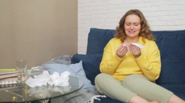 Kadın hapşırır ve burnunu mendile siler, nezle olur, salgın olur, enfeksiyon kapar. Alerjisi var. Burnunu ovuyor, mendili sıkıyor ve masaya koyuyor. Rhinitis