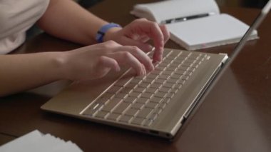 Kadın eller dizüstü bilgisayarın klavyesinde yazı yazıyorlar. Parmaklar klavyedeki tuşlara hızlıca basın. Onun yanında bir defter var. Kişisel bilgisayar, evde uzaktan çalışma, iş, çalışma, mesajlaşma, sohbet