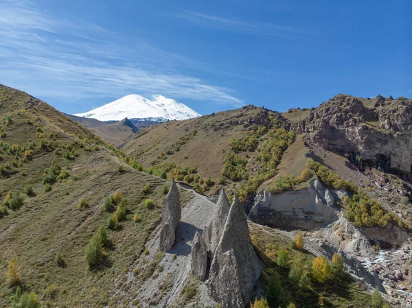 Dağ şelalesinin havadan görünüşü, Elbrus. Dağdaki keskin tepeler görülebilir. Fırtınalı nehir dağın tepesinden vadiye doğru akıyor ve yerden kırılıyor. Güneşli hava