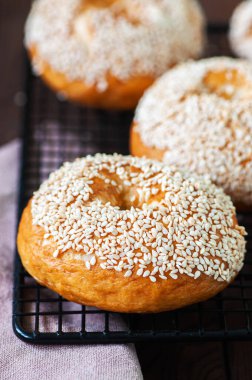 Soğutma rafında taze pişmiş susamlı simit. Kapat..