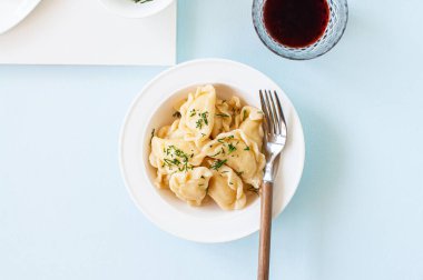 Beyaz tabakta tereyağı ve yeşillikle doldurulmuş lezzetli patatesler..