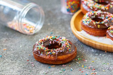 Renkli şekerli çikolatalı donutlar. Gri arka plan. Kapat..