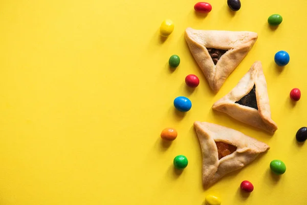 Ovanifrån Hamantaschen Cookies Och Färgglada Godis Gul Bakgrund Kopiera Utrymme — Stockfoto