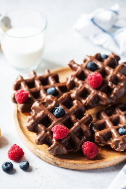 Belçika çikolatalı waffle 'ı, gri arka planda bir bardak süt..