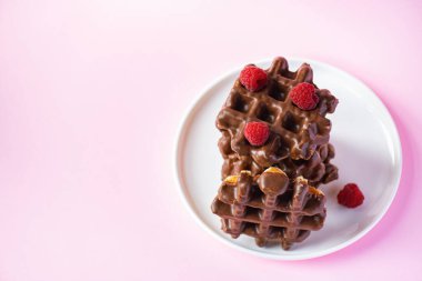 Böğürtlenli bir yığın çikolatalı waffle. Kapat ve pembe arkaplan.
