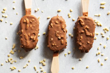 Tahta bir çubukta üç çikolatalı bademli dondurma. Üst görünüm.