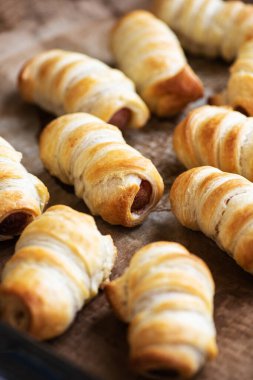 Pigs in a blanket - puff pastry baking with sausages.