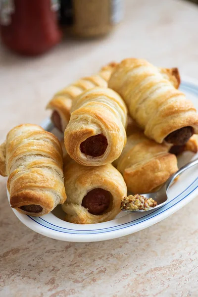 Pigs in a blanket - mini sausage roll on a plate.
