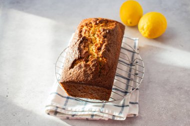 Lemon cake on a cooling rack on a gray background.