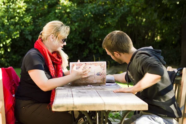 Young couple sitting in a summer cafe — Stock Photo, Image