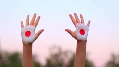 Japonya 'da boyalı çocuk elleri gökyüzü arka planında farklı işaretler yapıyor.. 